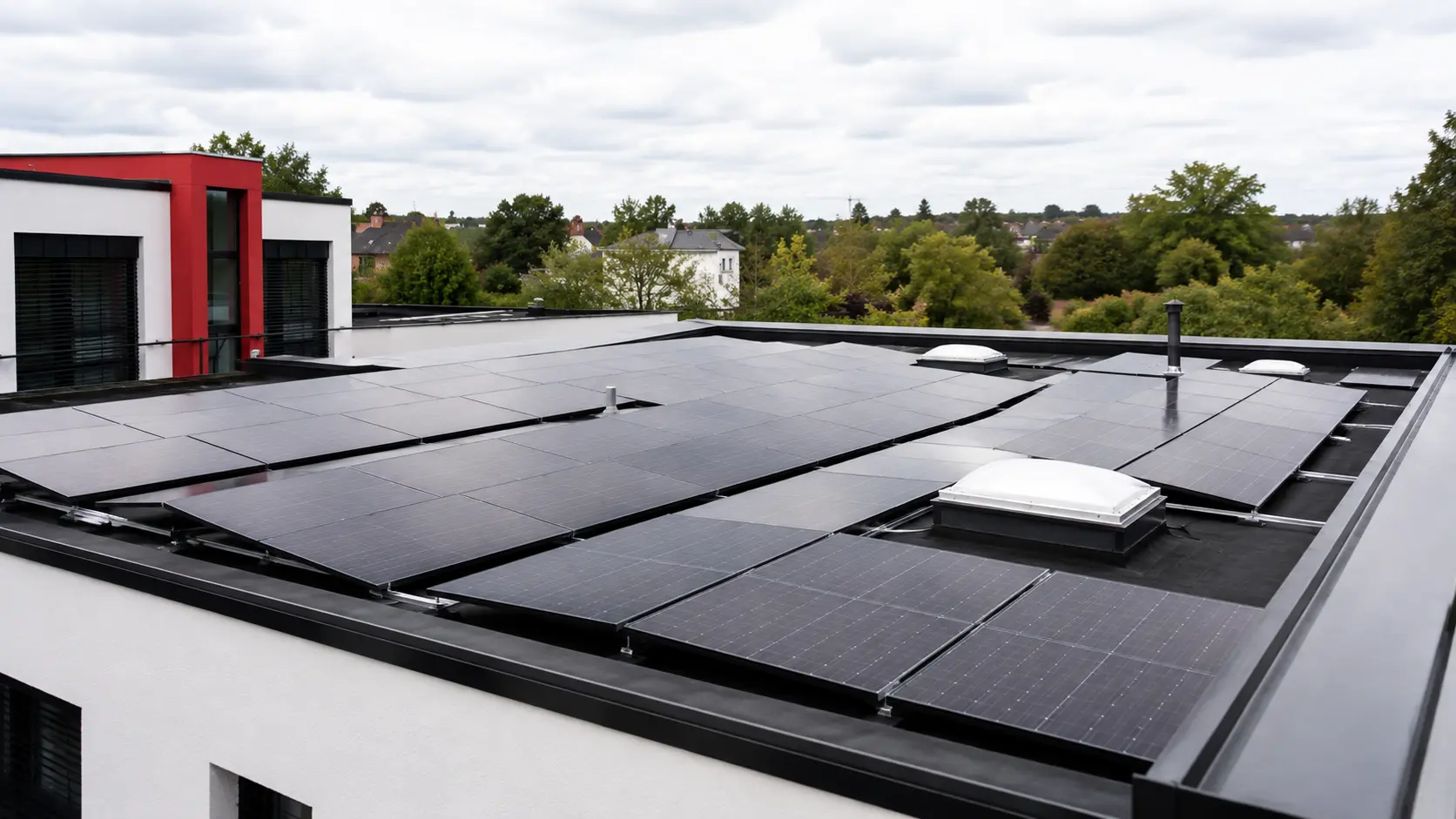 Fertig montierte Photovoltaikfläche auf einem Flachdach mit Lichtkuppeln und Attikaabdeckung